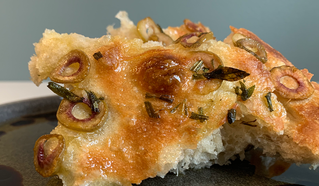 Piece of focaccia on a plate with oil and balsamic vinegar